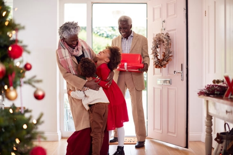 kids greeting grandparents at the door on christmas