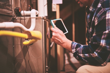 hvac technician inspecting furnace