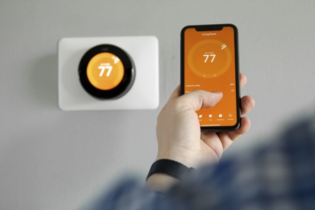 man changing thermostat on smartphone