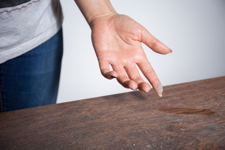 woman examining dusty table