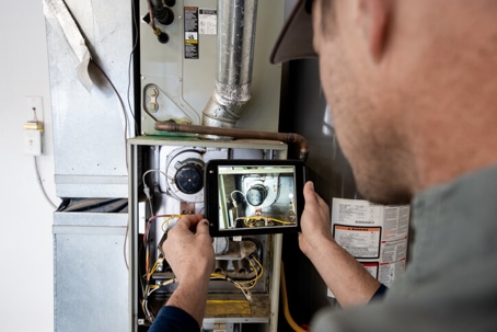 technician inspecting a furnace