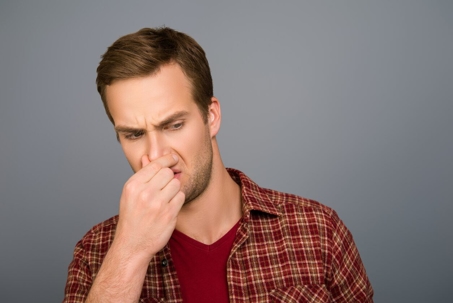 man holding his nose
