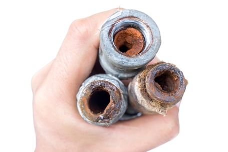 hand holding old corroded pipes